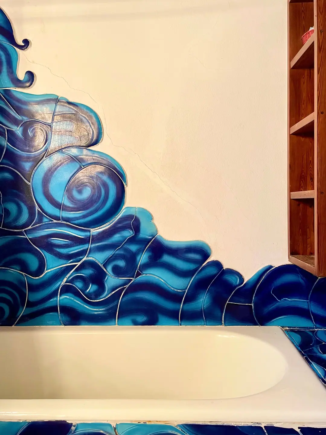 Bathtub wrapped in hand-painted ceramic waves