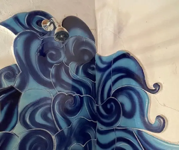 Hand-painted blue ceramic waves around the shower
